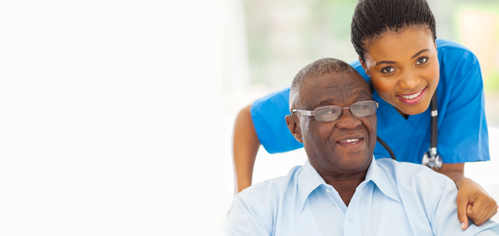 caregiver and senior man in wheelchair smiling