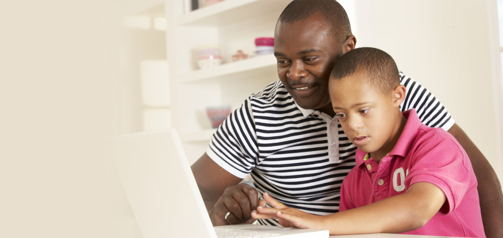 father and downs syndrome son with laptop