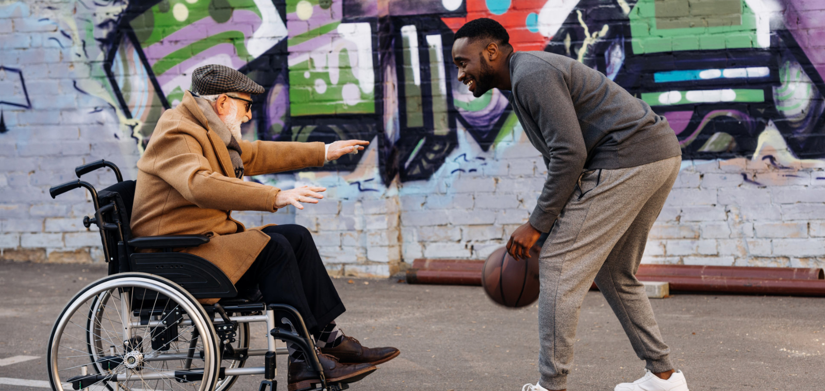 senior man and adult man smiling while playing the ball