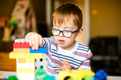 Little boy with Down syndrome playing blocks