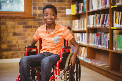 little boy sitting in wheelchair at the library