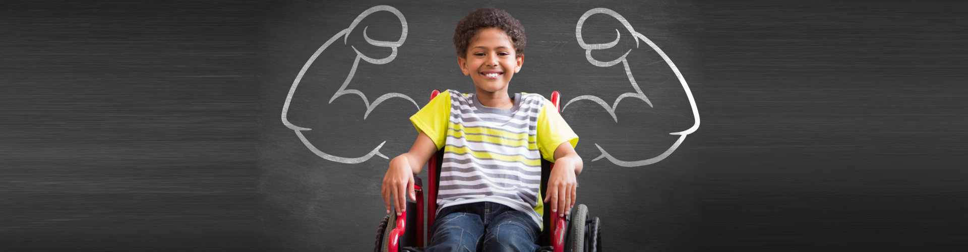 child sitting in wheelchair smiling at camera in hall against black background