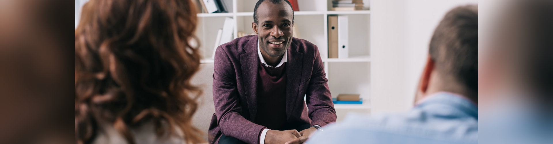 Smiling psychiatrist talking to divorcing couple in office