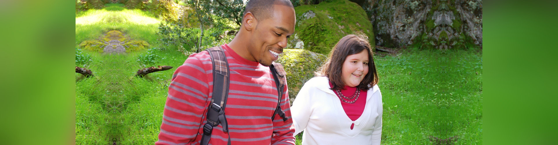 Young man walking with his visually impaired friend through a forest